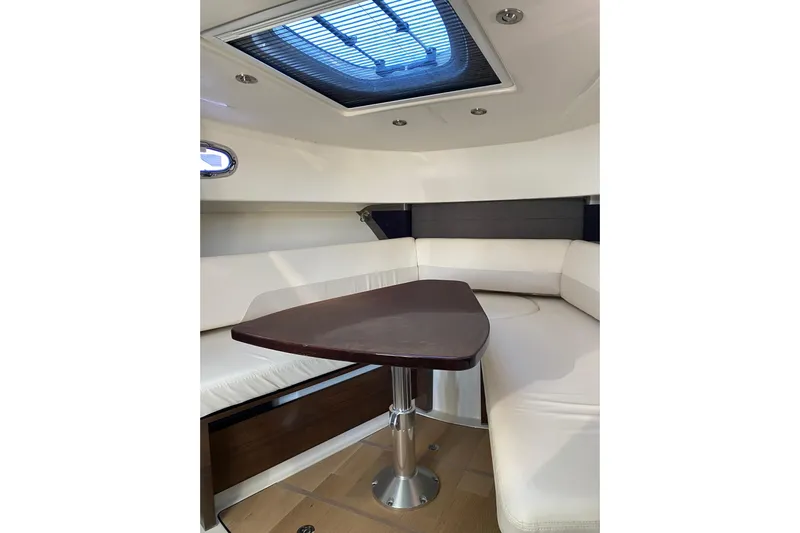 Yacht Photos Pics Interior of 2021 Boston Whaler 345 Conquest with white seating and wooden table.