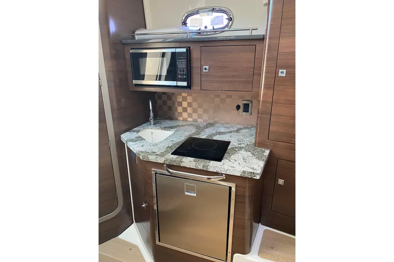  Yacht Photos Pics 2021 Boston Whaler 345 Conquest kitchen with microwave, sink, and induction cooktop.