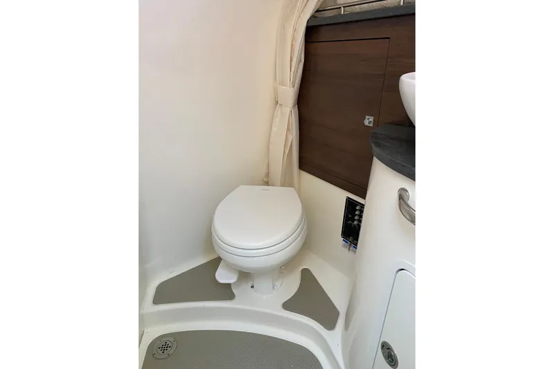  Yacht Photos Pics 2021 Boston Whaler 345 Conquest bathroom interior with toilet and wooden cabinetry.