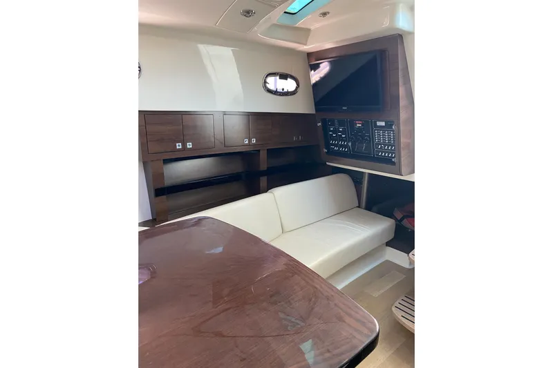  Yacht Photos Pics Interior of 2021 Boston Whaler 345 Conquest with sofa, table, and control panel.