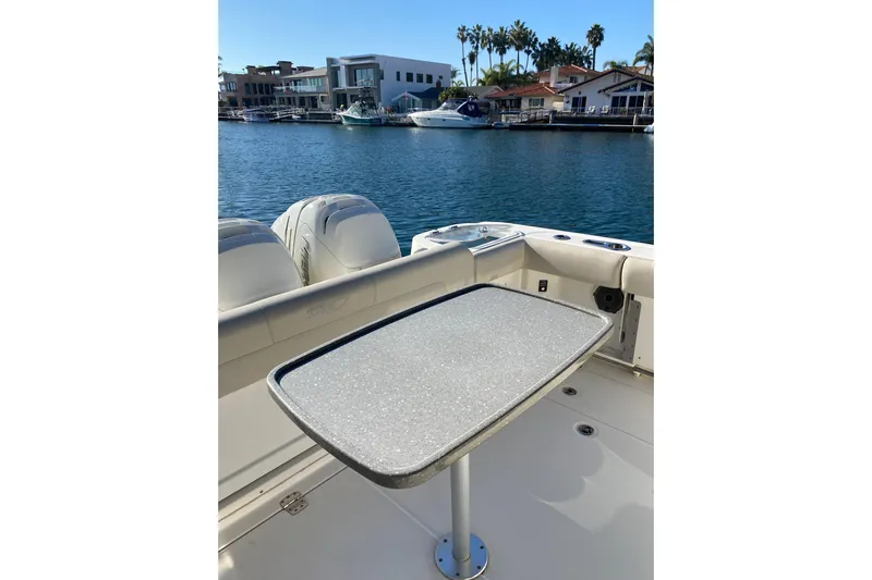  Yacht Photos Pics 2021 Boston Whaler 345 Conquest boat with table, docked in a scenic marina.