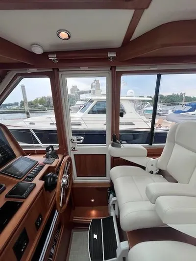 Seventeen Yacht Photos Pics Interior view of 2021 Sabre 45 Salon Express yacht cockpit with white captain's chair.