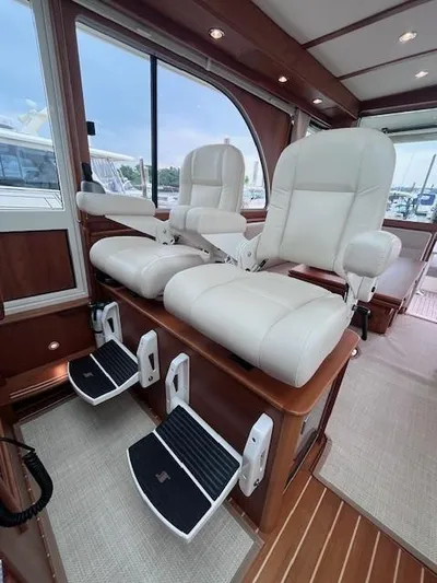 Seventeen Yacht Photos Pics Interior of 2021 Sabre 45 Salon Express with luxurious white captain chairs and footrests.
