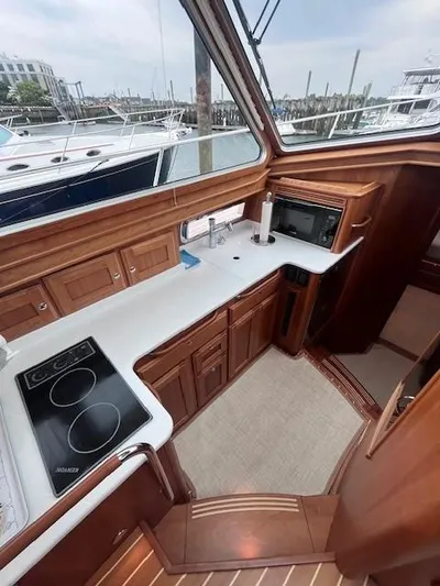 Seventeen Yacht Photos Pics 2021 Sabre 45 Salon Express yacht kitchen with wood cabinetry and modern appliances.