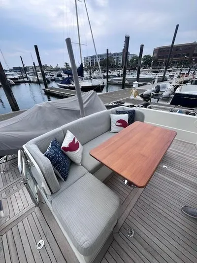 Seventeen Yacht Photos Pics 2021 Sabre 45 Salon Express yacht with outdoor seating and wooden table at marina.