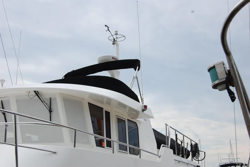 Wandering Bear Yacht Photos Pics 2001 Ocean Alexander Classico yacht with radar and antennas against cloudy sky.