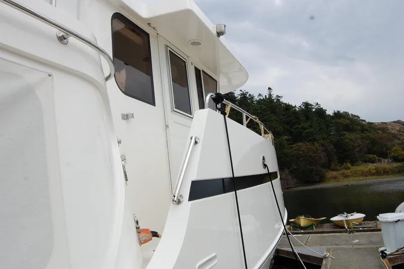 Wandering Bear Yacht Photos Pics 2001 Ocean Alexander Classico yacht docked near lush greenery and calm waters.