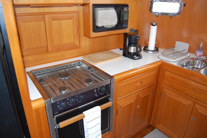 Wandering Bear Yacht Photos Pics Galley kitchen in 2001 Ocean Alexander Classico yacht with stove, microwave, and coffee maker.