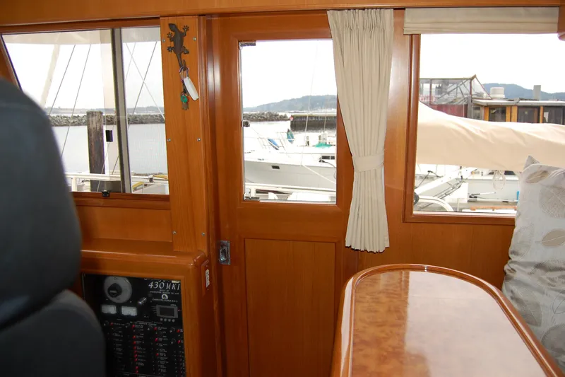 Wandering Bear Yacht Photos Pics Interior view of 2001 Ocean Alexander Classico yacht with wooden finish and marina backdrop.