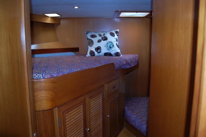 Wandering Bear Yacht Photos Pics Cozy cabin interior of 2001 Ocean Alexander Classico yacht with wooden finish and patterned bedding.
