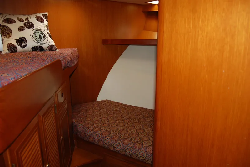 Wandering Bear Yacht Photos Pics Cozy cabin interior of 2001 Ocean Alexander Classico yacht with wooden finish and patterned bedding.