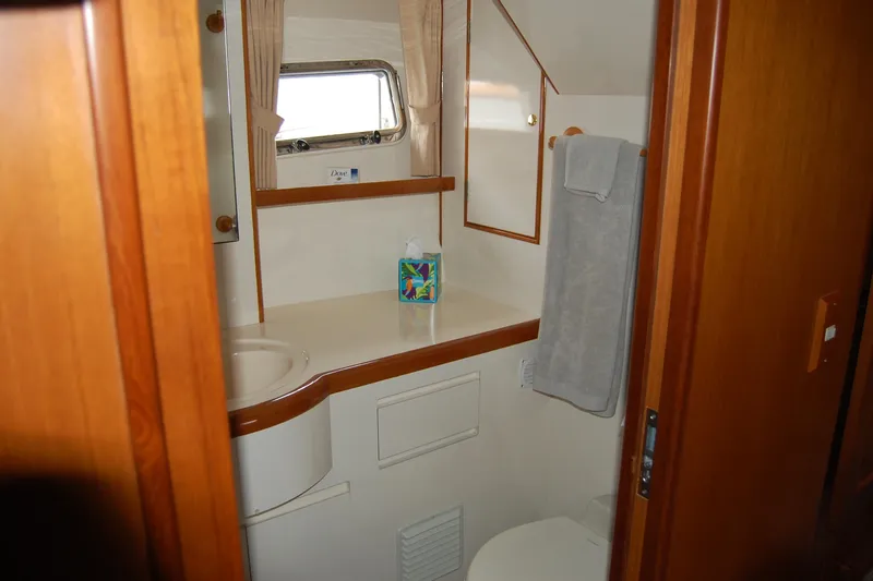 Wandering Bear Yacht Photos Pics Bathroom interior of 2001 Ocean Alexander Classico yacht with wooden accents and window.