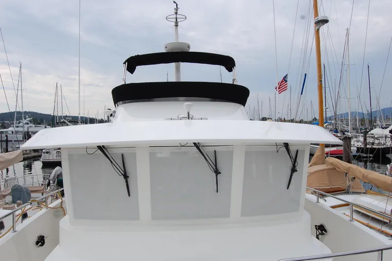 Wandering Bear Yacht Photos Pics 2001 Ocean Alexander Classico yacht docked at marina with American flag in background.
