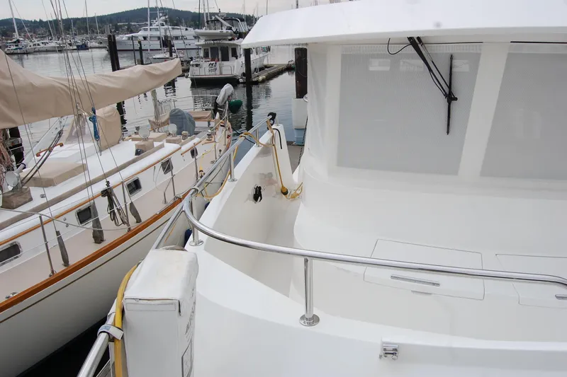 Wandering Bear Yacht Photos Pics 2001 Ocean Alexander Classico yacht docked at marina, featuring sleek white design and railing.