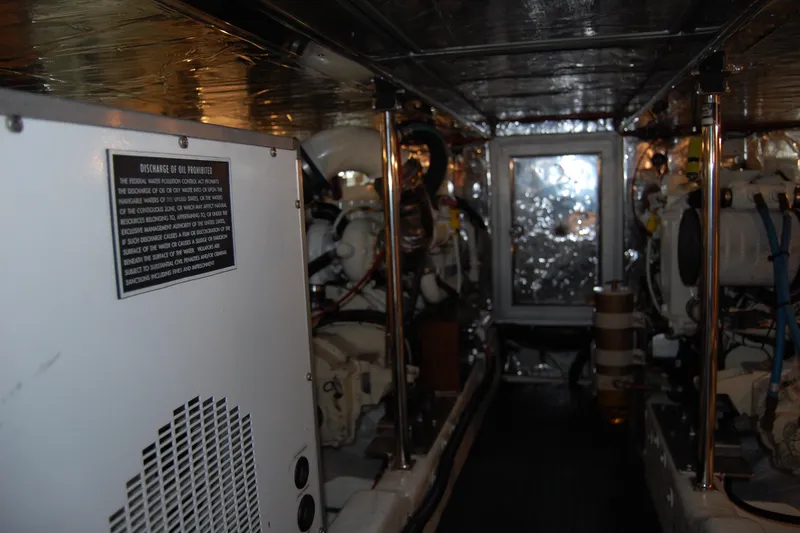 Wandering Bear Yacht Photos Pics Engine room of 2001 Ocean Alexander Classico yacht, featuring machinery and safety signage.