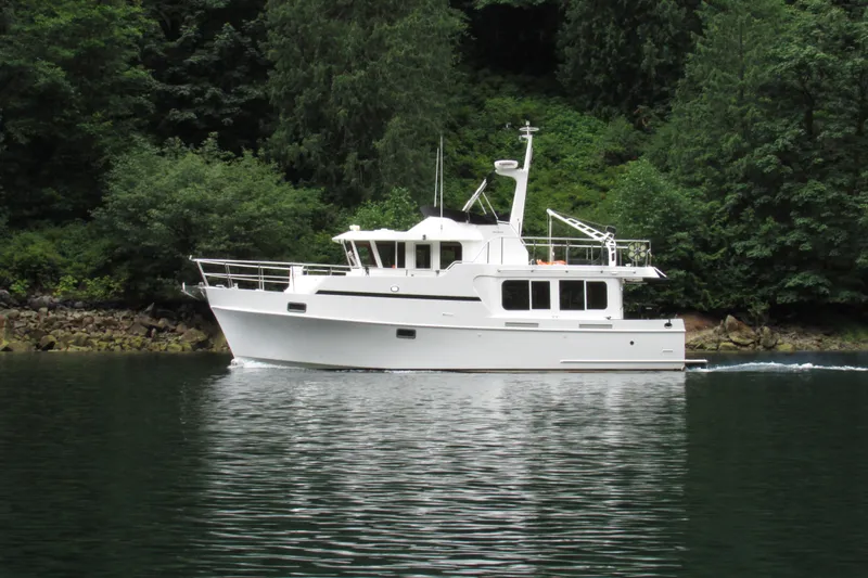 Wandering Bear Yacht Photos Pics 2001 Ocean Alexander Classico yacht cruising on a serene lake surrounded by lush greenery.