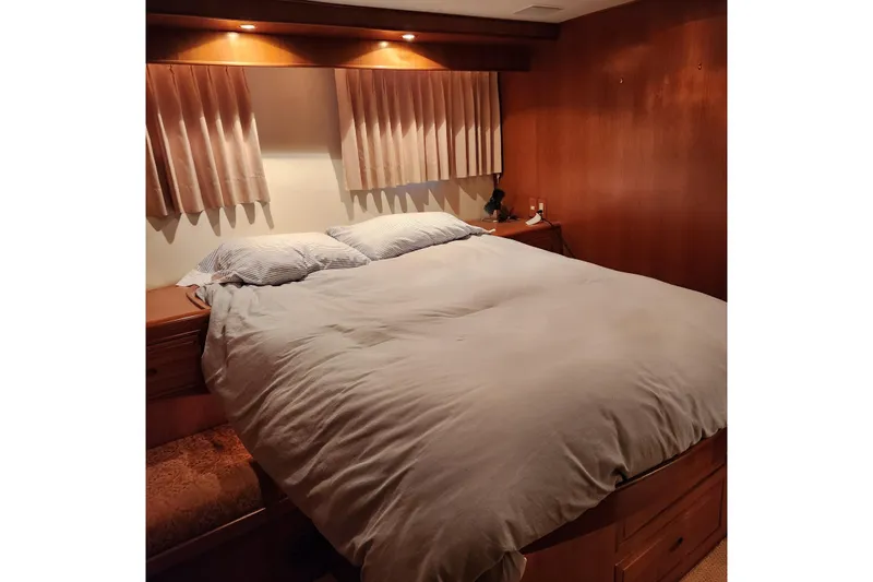 Wandering Bear Yacht Photos Pics Cozy bedroom in 2001 Ocean Alexander Classico yacht with wood paneling and soft lighting.