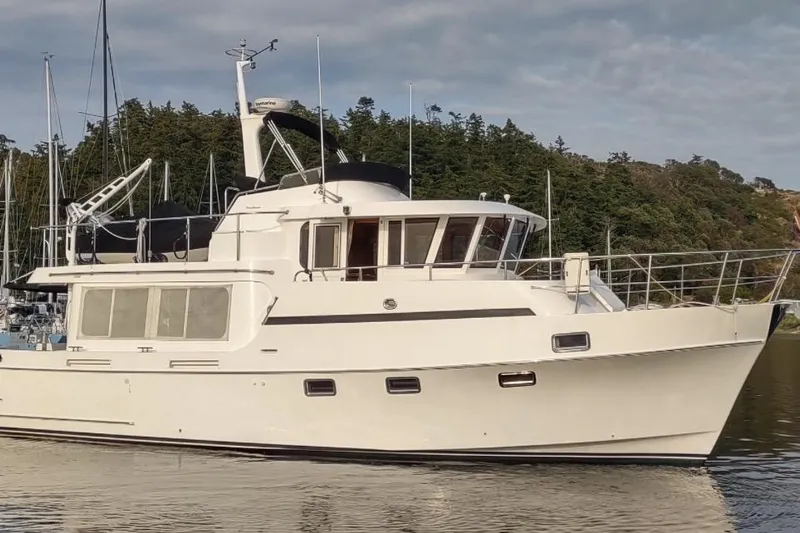 Wandering Bear Yacht Photos Pics Ocean Alexander Classico 2001 yacht docked, surrounded by trees and calm water.