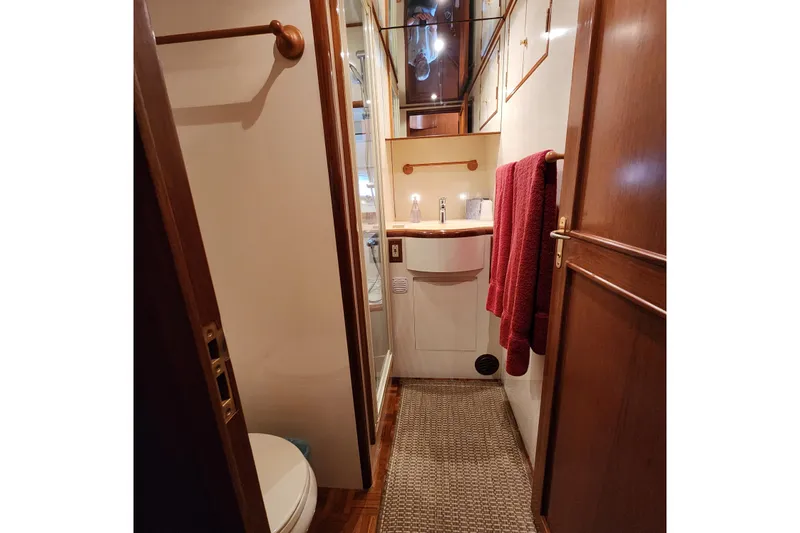Wandering Bear Yacht Photos Pics Bathroom interior of 2001 Ocean Alexander Classico yacht with wooden accents and red towels.