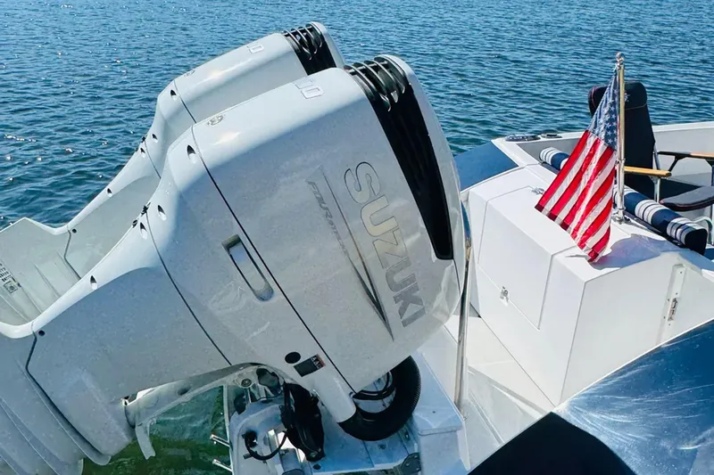 Forever Moor Yacht Photos Pics 2024 True North 34 Outboard Express with Suzuki engines and American flag on water.