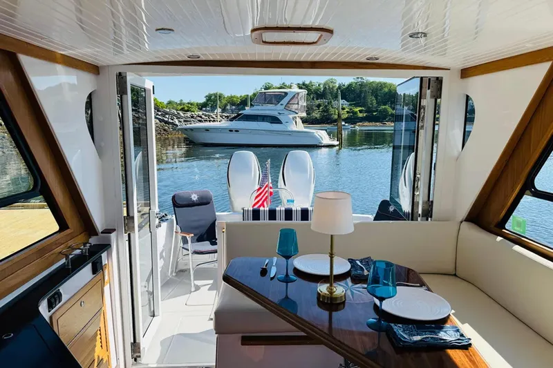 Forever Moor Yacht Photos Pics Interior view of 2024 True North 34 Outboard Express yacht with elegant dining setup.