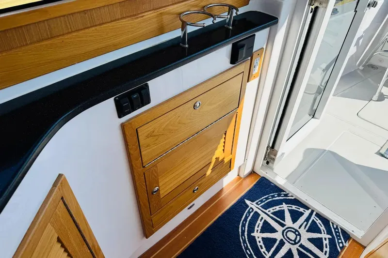 Forever Moor Yacht Photos Pics 2024 True North 34 Outboard Express interior with wooden cabinetry and nautical-themed decor.