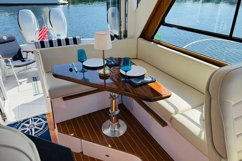 Forever Moor Yacht Photos Pics 2024 True North 34 Outboard Express interior with elegant dining setup and lake view.