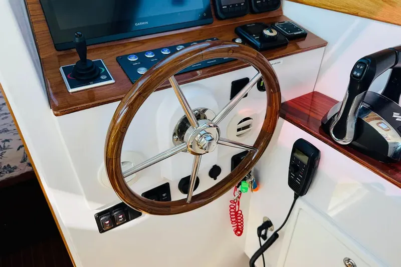 Forever Moor Yacht Photos Pics Steering console of 2024 True North 34 Outboard Express with wooden wheel and controls.