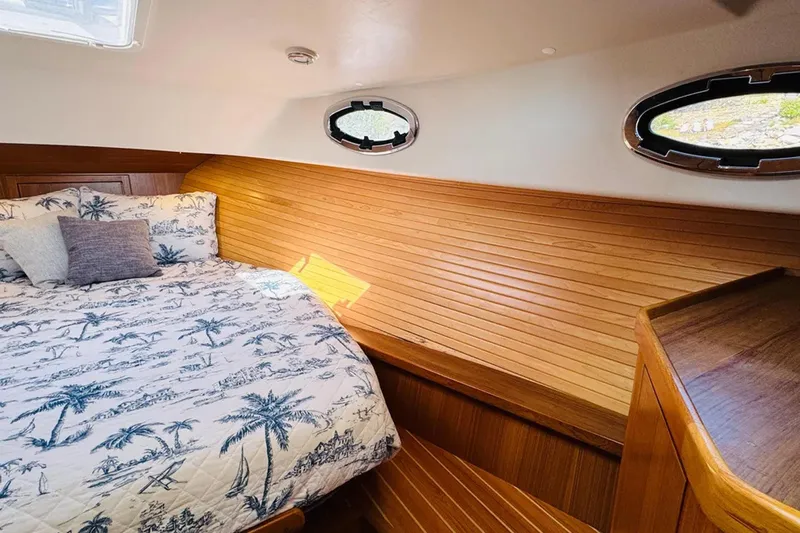 Forever Moor Yacht Photos Pics 2024 True North 34 Outboard Express cabin with wood paneling and nautical-themed bedding.