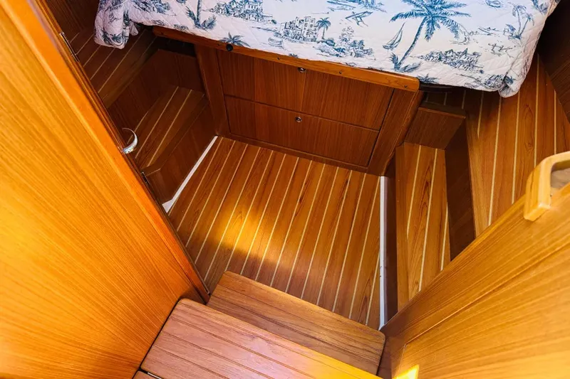 Forever Moor Yacht Photos Pics 2024 True North 34 Outboard Express cabin interior with wooden flooring and nautical bedding.