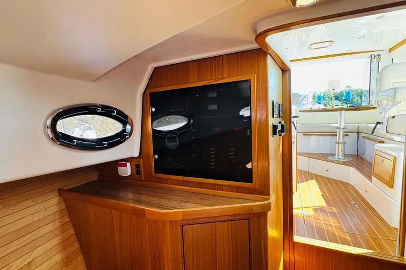 Forever Moor Yacht Photos Pics 2024 True North 34 Outboard Express interior with wood paneling and porthole window.