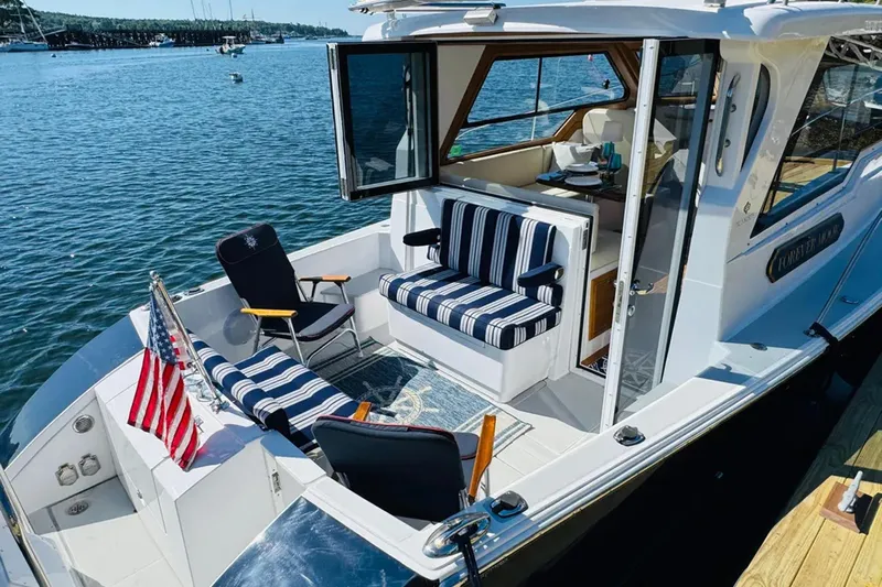 Forever Moor Yacht Photos Pics 2024 True North 34 Outboard Express boat with striped seating, docked on a sunny day.