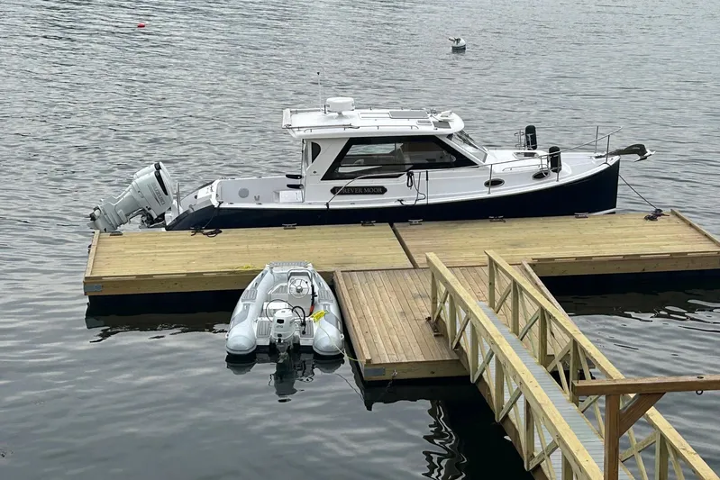 Forever Moor Yacht Photos Pics 2024 True North 34 Outboard Express docked with inflatable boat nearby.