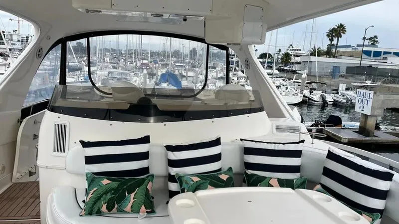  Yacht Photos Pics 2002 Sea Ray 560 Sedan Bridge yacht interior with striped and leaf-patterned cushions in marina setting.