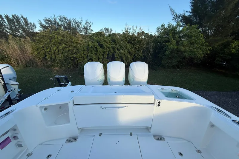  Yacht Photos Pics 2018 Edgewater 370CC boat with triple engines, surrounded by lush greenery.