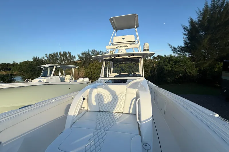  Yacht Photos Pics 2018 Edgewater 370CC boat with Garmin equipment, docked near trees under clear sky.