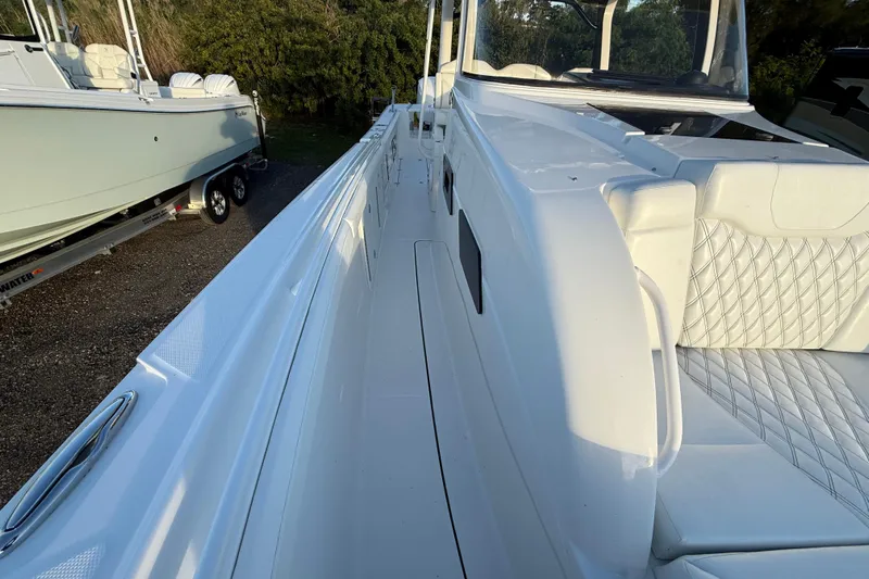  Yacht Photos Pics 2018 Edgewater 370CC boat with white seating and sleek design, parked outdoors.