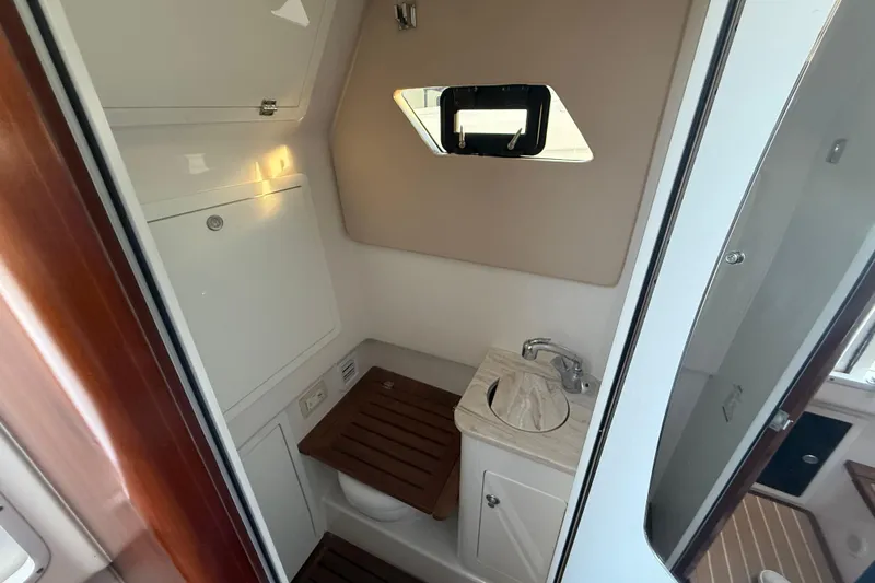  Yacht Photos Pics 2018 Edgewater 370CC boat bathroom with sink, toilet, and window.
