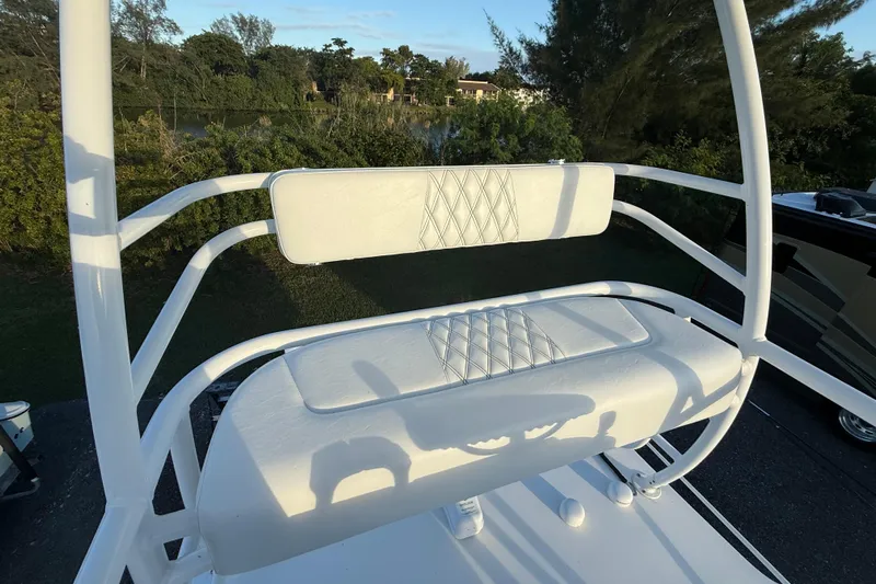  Yacht Photos Pics 2018 Edgewater 370CC boat seating with white cushioned bench and backrest, surrounded by greenery.