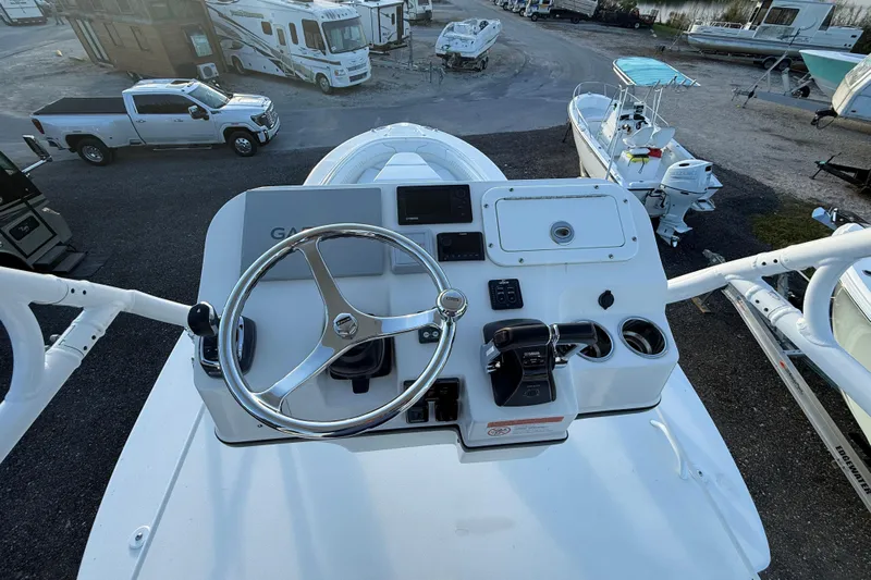  Yacht Photos Pics 2018 Edgewater 370CC boat helm with steering wheel and controls, parked near RVs and trucks.