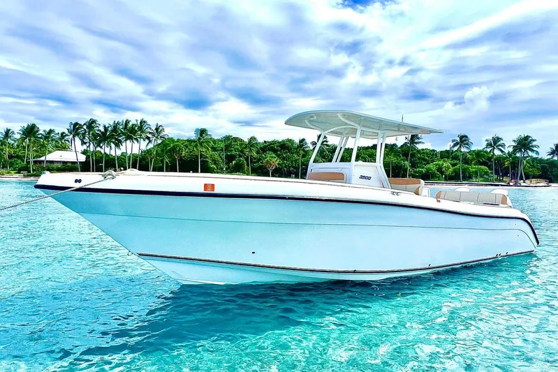  Yacht Photos Pics 2019 Century 3200 Center Console boat on clear turquoise water, with palm trees in the background.
