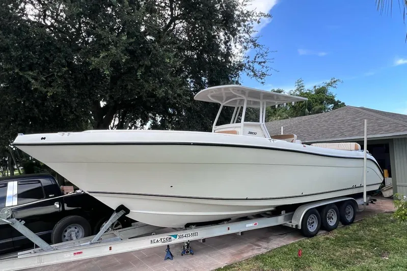  Yacht Photos Pics 2019 Century 3200 Center Console boat on trailer, parked near a house.