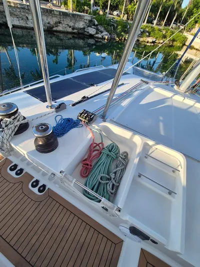 Chapter Two Yacht Photos Pics 2014 Lagoon 450 yacht deck with ropes and winches, docked by lush greenery.