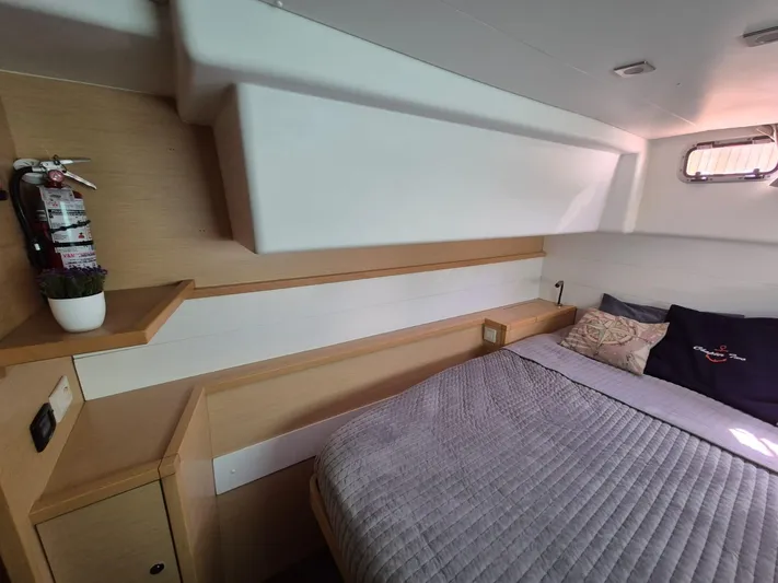 Chapter Two Yacht Photos Pics Cozy cabin interior of 2014 Lagoon 450 catamaran with bed and fire extinguisher.