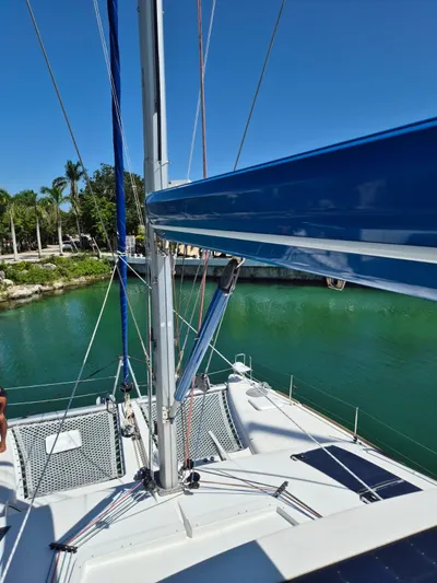 Chapter Two Yacht Photos Pics 2014 Lagoon 450 catamaran docked by lush greenery and calm waters.