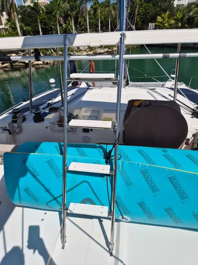 Chapter Two Yacht Photos Pics 2014 Lagoon 450 catamaran deck with ladder and blue paddleboard.