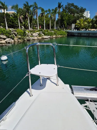 Chapter Two Yacht Photos Pics Bow of 2014 Lagoon 450 catamaran docked in tropical marina with lush greenery.