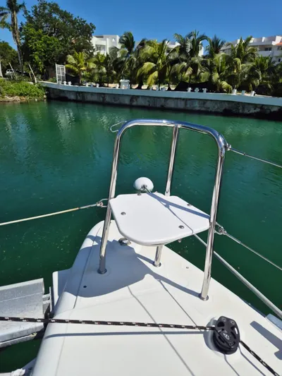Chapter Two Yacht Photos Pics Lagoon 450 catamaran bow with railing, docked near tropical greenery, 2014 model.
