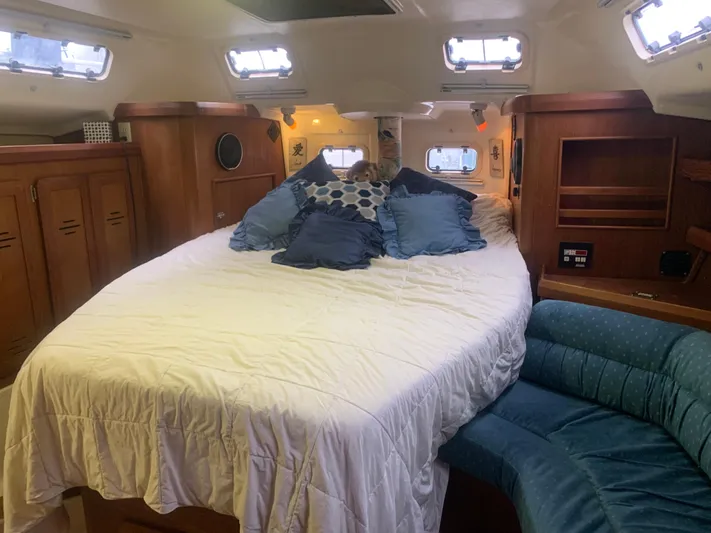  Yacht Photos Pics Cozy cabin interior of 1998 Hunter Passage 42 sailboat with bed and seating area.