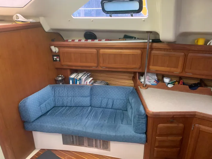  Yacht Photos Pics Interior of 1998 Hunter Passage 42 yacht with blue sofa and wooden cabinetry.